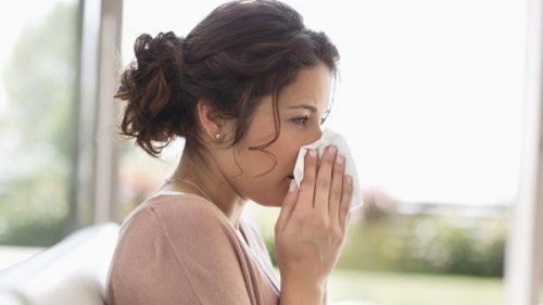 Woman blowing her nose