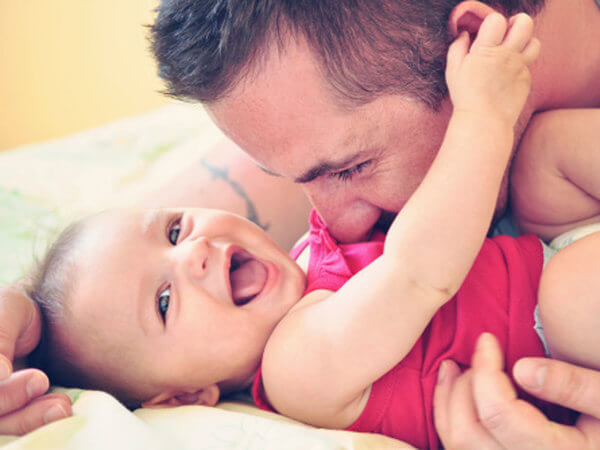Father cuddling with smiling baby