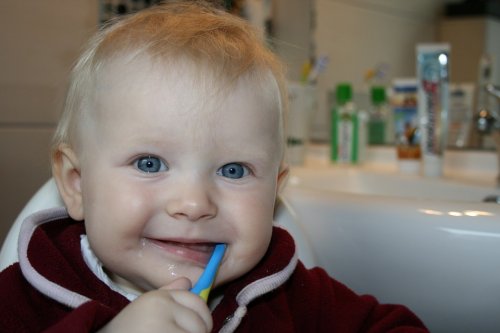 Baby brushing first tooth