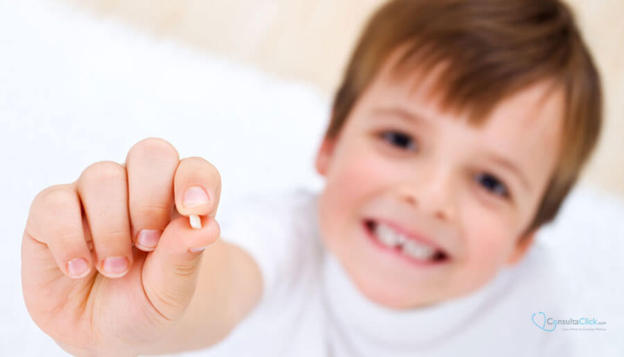Boy smiling and showing a tooth in his hand