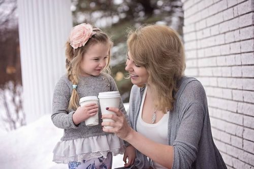 Mom and daughter holding to-go cups