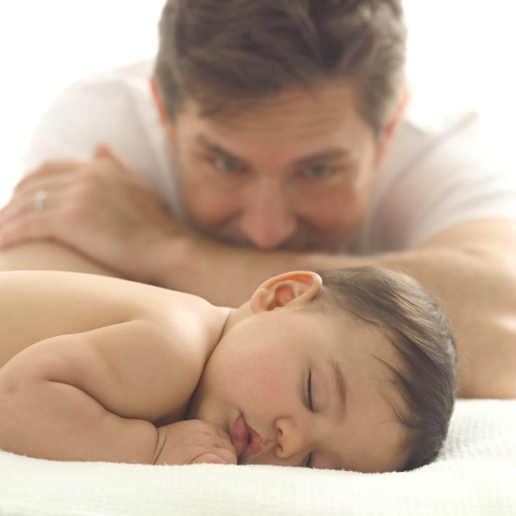 Father looking at sleeping baby