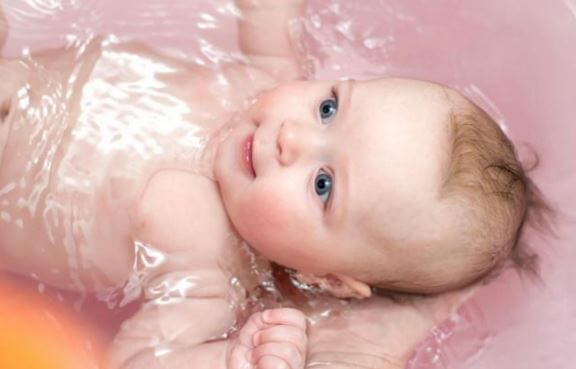 Lille baby bliver badet