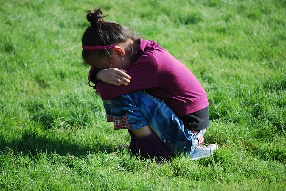 Girl crying alone in the grass