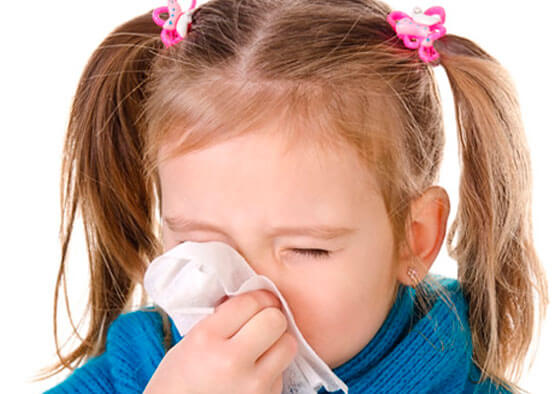 girl blowing her nose with a cold