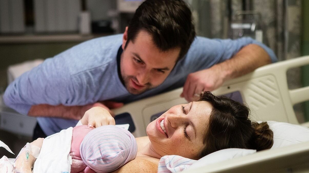 Mother and father looking at newborn