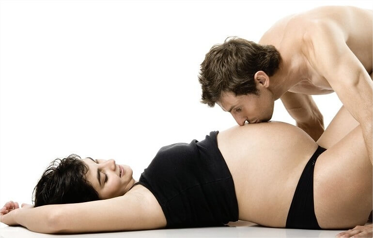 Man kissing belly of pregnant woman