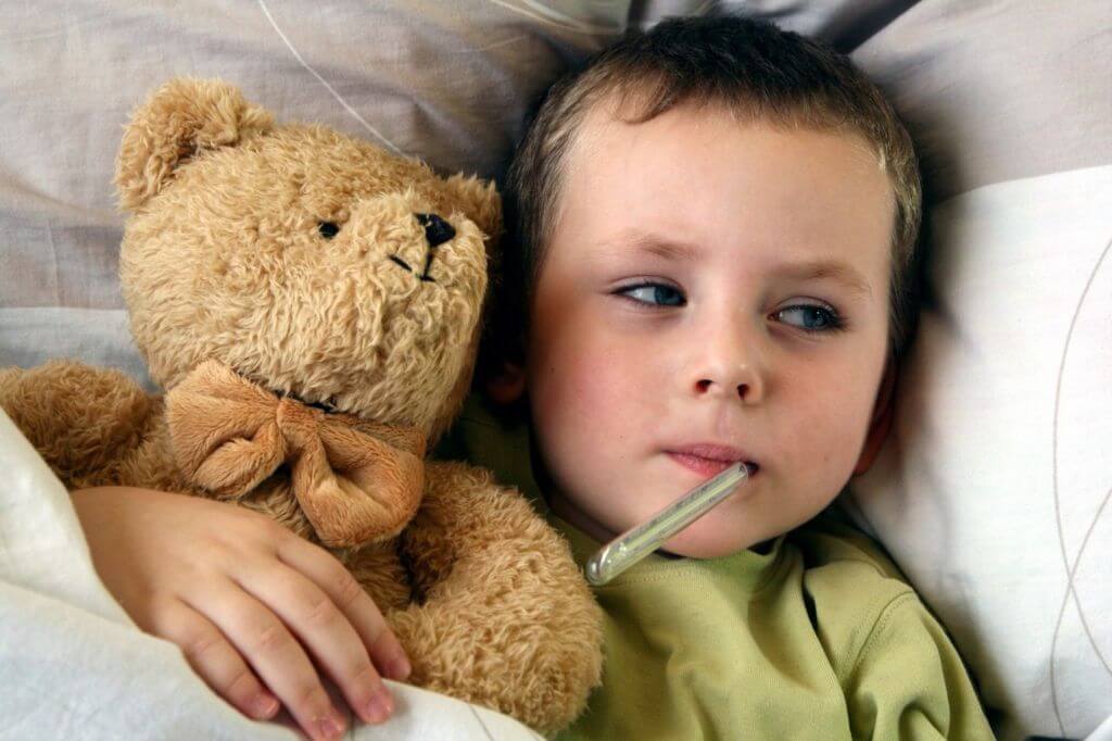 boy with a thermometer and teddy bear
