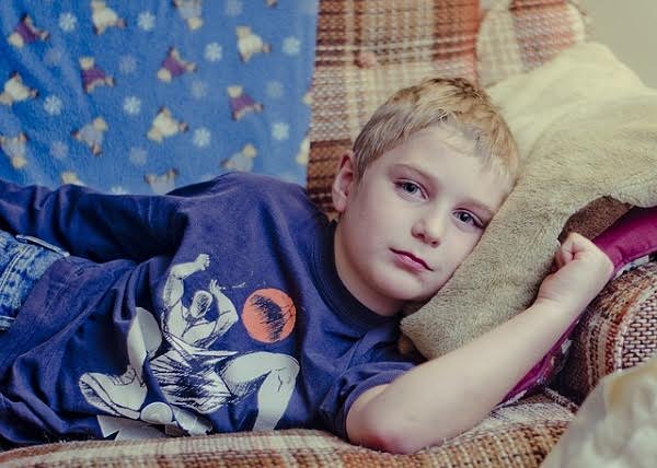 Boy lying on couch with appendicitis
