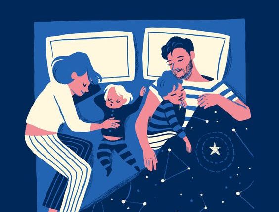 Mother and father holding children in bed