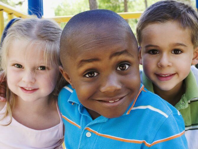three children smiling at the camera