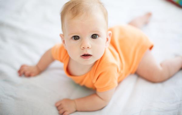 Baby lying on bed
