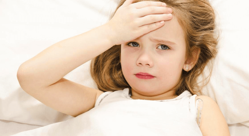 A girl with a headache holding her forehead