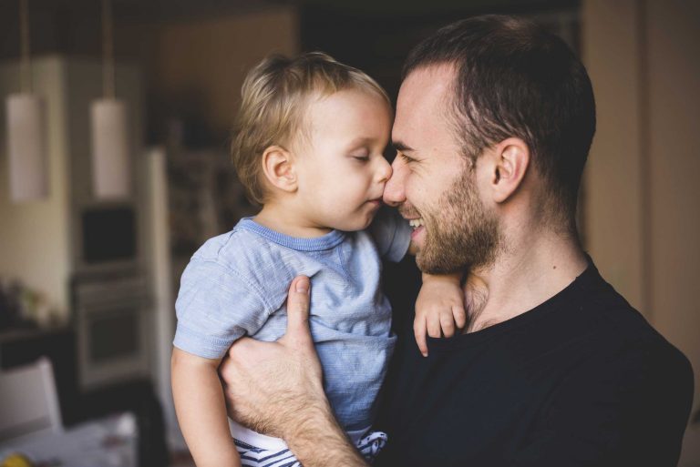 Father holding baby and smiling