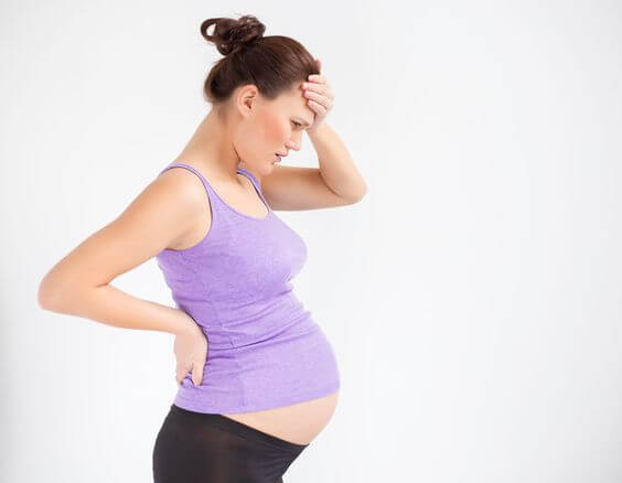 pregnant woman holding her head