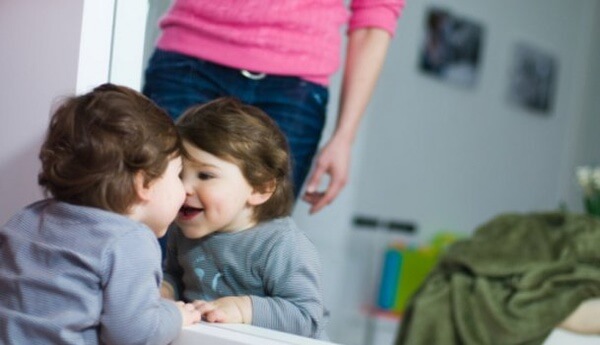 baby smiling in front of mirror