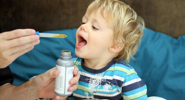 Boy taking his medicine dropper