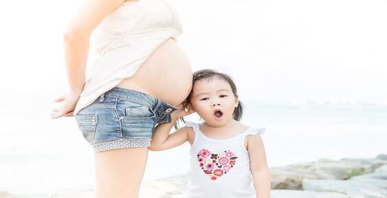 pregnant woman standing near daughter