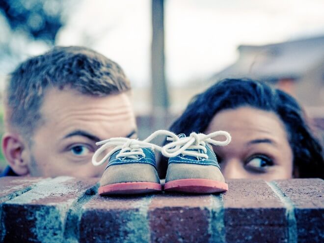 first-time parents looking at baby shoes