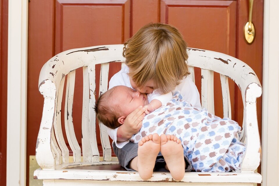 baby boy hugging newborn sibling
