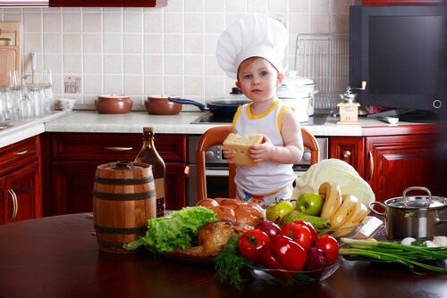 toddler in kitchen wearing a chef hat