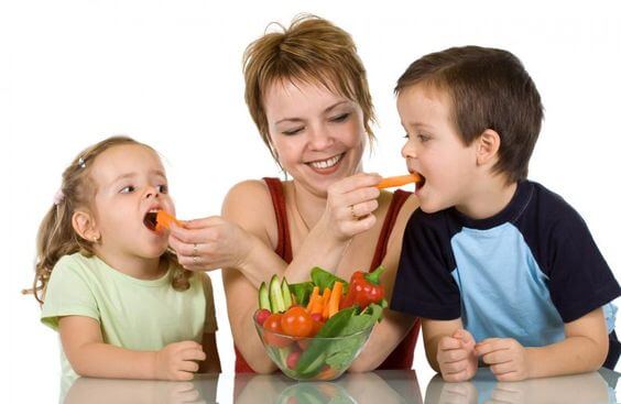 mor der fodrer børn med grøntsager