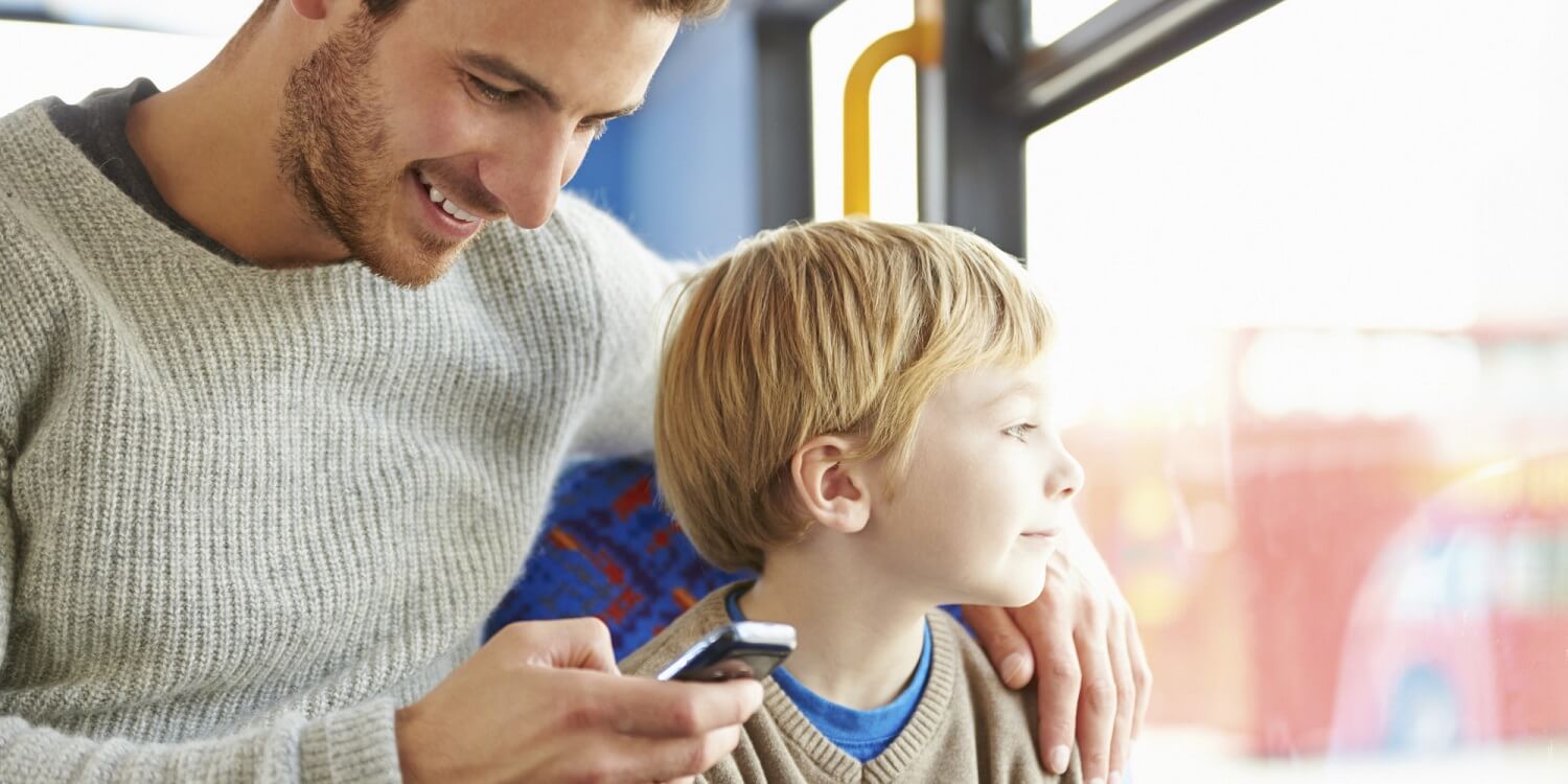 Pappa på mobil samtidigt med sitt barn