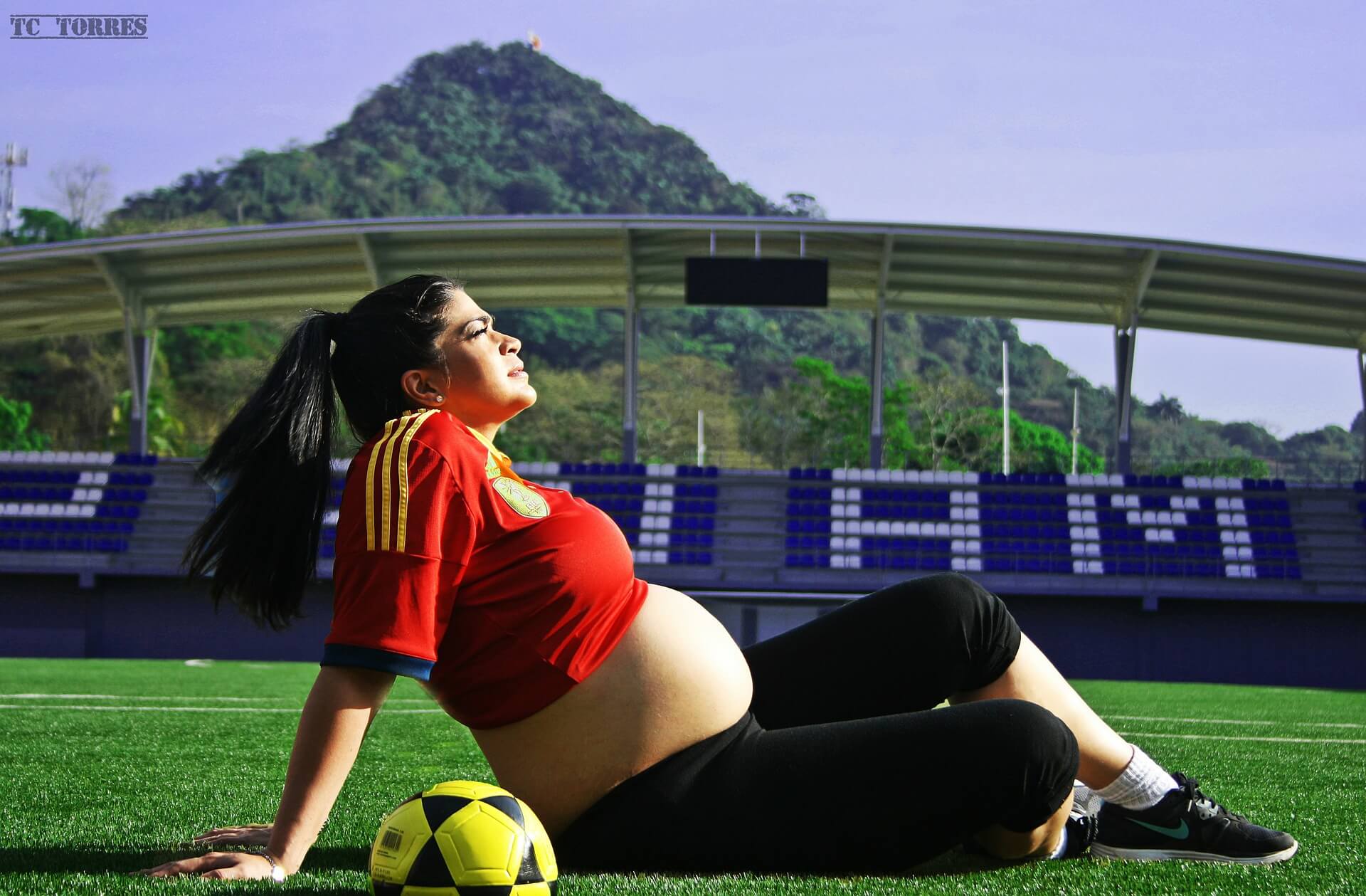 pregnant woman sitting on soccer field