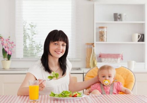 mom eating a salad next to her baby
