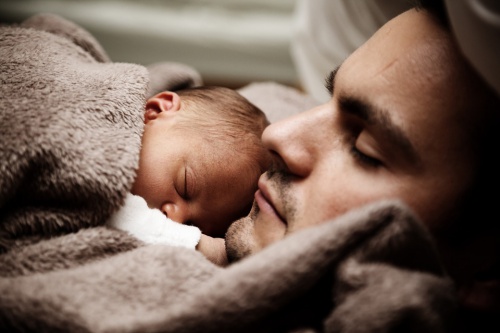 father sleeping with newborn son