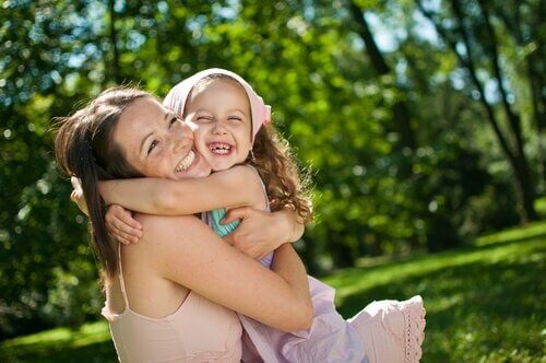 mother smiling with her daughter in the park