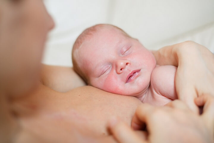 mother holding newborn right after childbirth