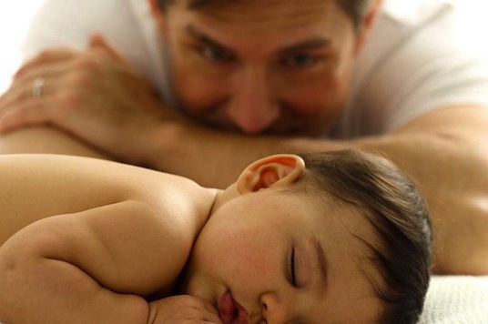 father looking at sleeping baby