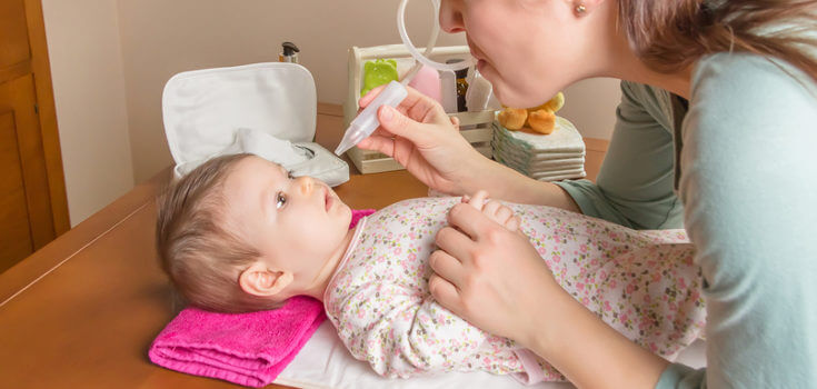 mother giving baby saline solution for the flu