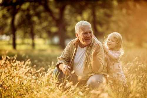 grandfather playing with granddaughter in a park