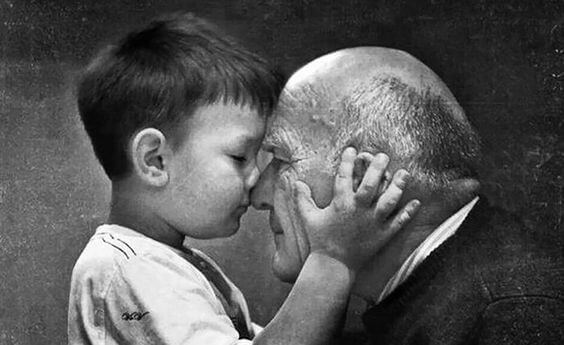 A grandchild holding his grandfather's head in his hands.