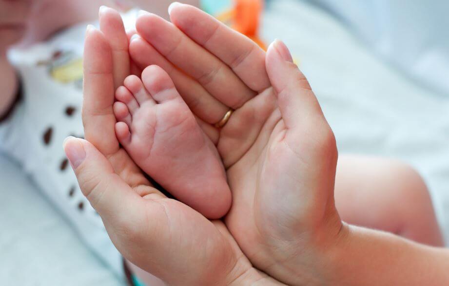 mother's hands and baby feet