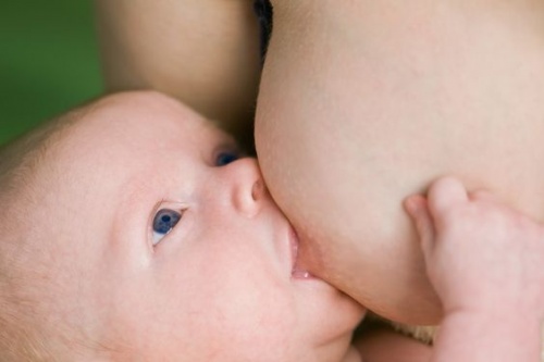 newborn baby being breastfed