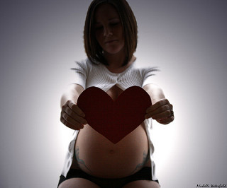 pregnant woman holding a heart