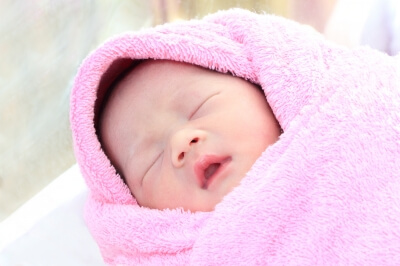 baby bundled up in a pink blanket