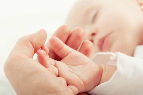 mother's hand and baby's hand while sleeping