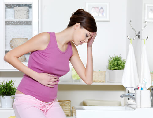 women holding head and belly during postpartum period