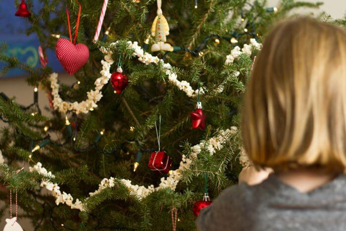 mom thinking about toys beside christmas tree
