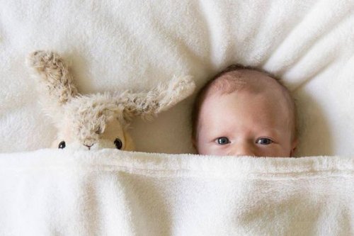 newborn baby sleeping with stuffed animal