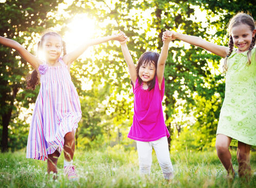 girls holding hands and playing in the park