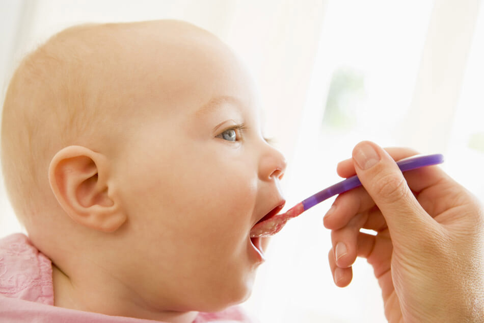 A baby being spoon-fed.