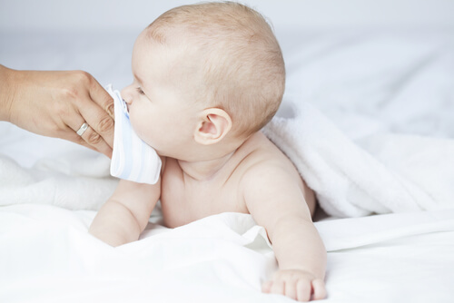 forælder der pudser en babys næse