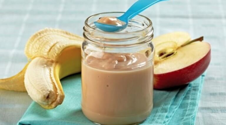 A banana, half and apple, and a jar of baby food.