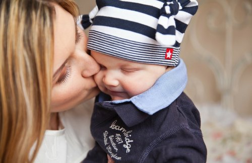 kvinde der kysser sin baby på kinden