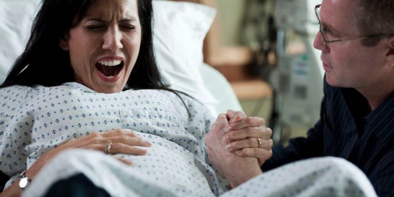 kvinde der er ved at føde sin baby
